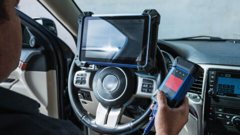 mechanic uses electronic tool to test emissions on a vehicle Harmony Automotive Denver Aurora Centennial Greeley Colorado