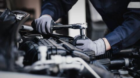 mechanic wearing gloves while tightening parts on a clean vehicle Harmony Automotive Denver Aurora Centennial Greeley Colorado