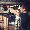 mechanic wearing gloves while tightening parts on a clean vehicle Harmony Automotive Denver Aurora Centennial Greeley Colorado